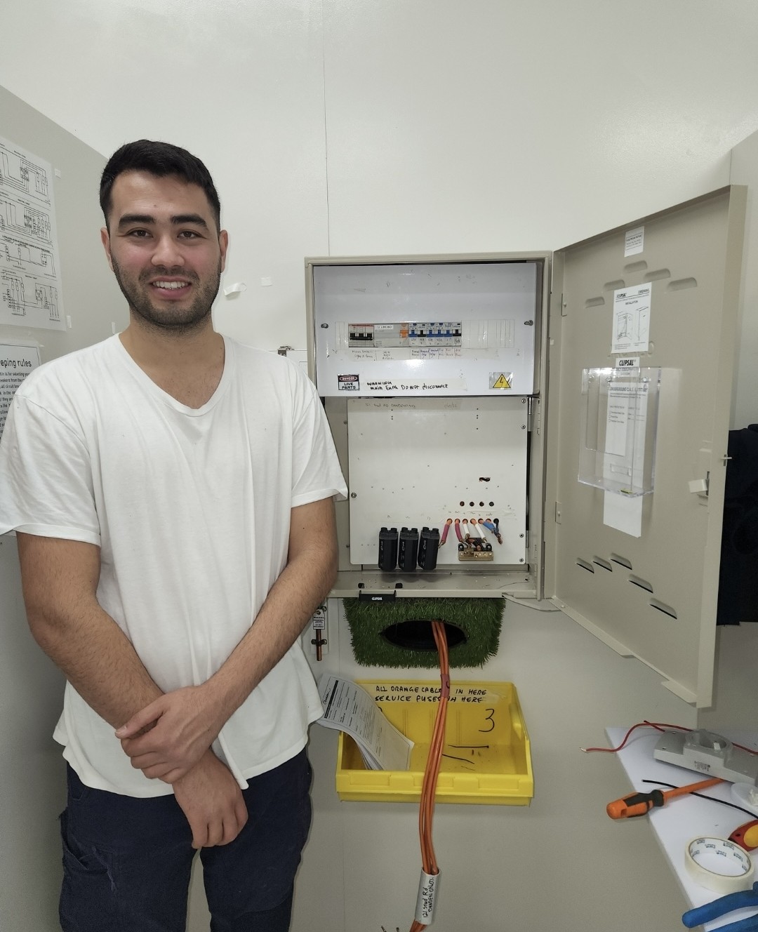 Leo Young, owner of Cablecore Electrical, standing beside a completed switchboard
