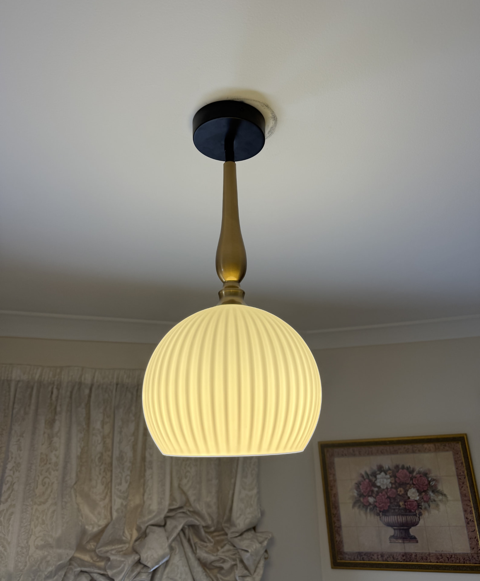 Ribbed glass pendant light installed on a brass ceiling fitting
